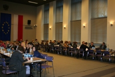 Uczestnicy seminarium  siedzą w ławkach na Auli