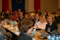 Uczestnicy seminarium  siedzą w ławkach na Auli
